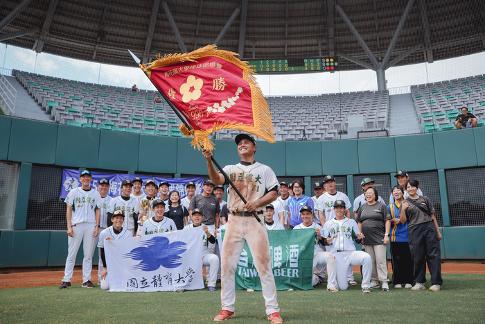 棒球隊隊長馬承恩同學揮冠軍錦旗