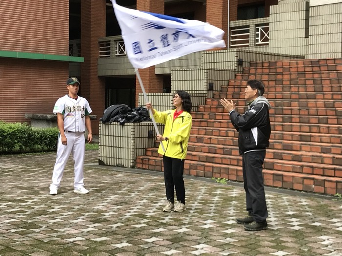 由高校長俊雄授旗，領隊詹副校長貴惠接旗