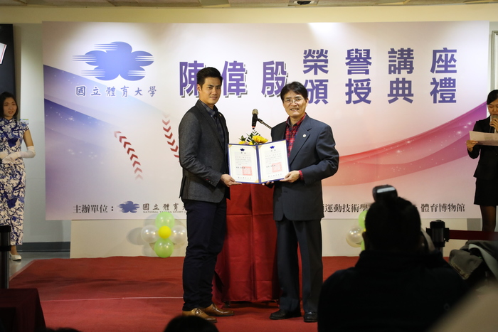 由高校長俊雄(右)頒授續聘贈書給邁阿密馬林魚隊台灣投手陳偉殷（左）受聘擔任榮譽講座