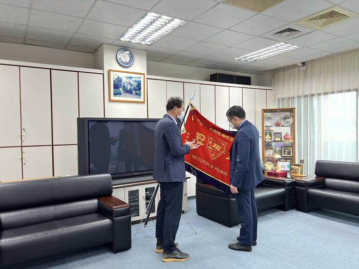 棒球隊龔榮堂教練與丁董事長分享棒球隊參加110學年度大專棒球聯賽冠軍旗